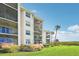 Condo building showing screened balconies, tropical landscaping, and well-maintained lawn at 850 Tidewater Shores Loop # 102, Bradenton, FL 34208