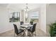 Cozy dining area features a glass table, modern chairs, and natural light from the window at 850 Tidewater Shores Loop # 102, Bradenton, FL 34208