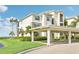 Exterior building shot with covered parking for residents and tropical landscaping at 850 Tidewater Shores Loop # 102, Bradenton, FL 34208