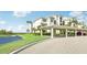 Building exterior shot with covered parking for residents and tropical landscaping at 850 Tidewater Shores Loop # 102, Bradenton, FL 34208