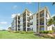 Condo building showcasing multiple screened-in balconies, lush landscaping, and well-maintained green lawn at 850 Tidewater Shores Loop # 102, Bradenton, FL 34208