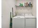 Laundry room with white washer and dryer with shelving above and cleaning supplies at 850 Tidewater Shores Loop # 102, Bradenton, FL 34208