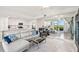 Open-concept living room with view of modern kitchen, and large mirror reflecting water views from sliding glass door at 850 Tidewater Shores Loop # 102, Bradenton, FL 34208