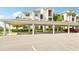 Exterior building shot with covered parking for residents and tropical landscaping at 850 Tidewater Shores Loop # 102, Bradenton, FL 34208