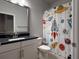 Colorful bathroom with modern vanity and whimsical shower curtain at 8706 Arrow Creek Dr, Parrish, FL 34219