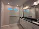 Bathroom featuring double vanity with modern fixtures, sleek countertop, and glass-enclosed shower with tiled walls at 8706 Arrow Creek Dr, Parrish, FL 34219
