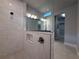 Modern bathroom featuring tiled shower with glass enclosure and niche for storage, adjacent to walk-in closet at 8706 Arrow Creek Dr, Parrish, FL 34219