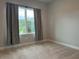 Bright bedroom featuring neutral carpet, and a large window showcasing lush greenery and natural light at 8706 Arrow Creek Dr, Parrish, FL 34219