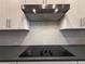 Modern kitchen features stainless steel range hood and sleek electric cooktop at 8706 Arrow Creek Dr, Parrish, FL 34219
