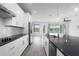 A stylish kitchen with white cabinetry, stainless steel appliances, and a view into the living room at 8706 Arrow Creek Dr, Parrish, FL 34219