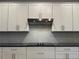 Stainless steel range hood with gray subway tile backsplash, and an electric cooktop at 8706 Arrow Creek Dr, Parrish, FL 34219