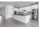 A modern kitchen featuring white cabinets, stainless steel appliances, and a large center island at 8706 Arrow Creek Dr, Parrish, FL 34219