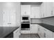 Modern kitchen features white cabinetry, stainless steel appliances, and a sleek black countertop at 8706 Arrow Creek Dr, Parrish, FL 34219