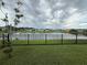 Enjoy tranquil lake views from the backyard with black metal fence and lush green grass at 8706 Arrow Creek Dr, Parrish, FL 34219