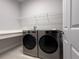Laundry room with sleek, modern washer and dryer, and ample counter space at 8706 Arrow Creek Dr, Parrish, FL 34219
