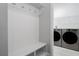 A convenient mudroom with bench, hooks, and access to a laundry room with washer and dryer at 8706 Arrow Creek Dr, Parrish, FL 34219