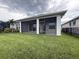 Covered screened patio with sliding glass doors overlooks the lush, green lawn and landscaping at 8706 Arrow Creek Dr, Parrish, FL 34219