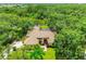 Expansive aerial view of a beautiful home with a tile roof, lush green lawn, mature trees, and a lake at 8717 Misty Creek Dr, Sarasota, FL 34241