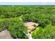 Aerial view of a home situated next to a pond surrounded by lush mature trees and greenery at 8717 Misty Creek Dr, Sarasota, FL 34241