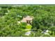 Areal view of a home surrounded by lush greenery and trees with a pond in the background at 8717 Misty Creek Dr, Sarasota, FL 34241