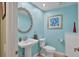 Stylish powder room with blue walls, pedestal sink, and round mirror add elegance at 8717 Misty Creek Dr, Sarasota, FL 34241