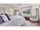 Bedroom featuring a white metal bed, a chest, a sitting chair, and a picturesque water view from the window at 8717 Misty Creek Dr, Sarasota, FL 34241
