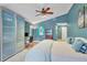 Bedroom with light blue walls, a bed, a ceiling fan, a furry rug, and a workstation with sliding glass doors at 8717 Misty Creek Dr, Sarasota, FL 34241