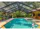 Relaxing screened-in pool and patio area with lush landscaping provides an oasis at 8717 Misty Creek Dr, Sarasota, FL 34241