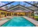 Beautiful screened-in pool and spa area with an outdoor bar and view of the water at 8717 Misty Creek Dr, Sarasota, FL 34241