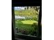 Inviting view of the lake and green lawn from the home's window offering peace and tranquility at 8717 Misty Creek Dr, Sarasota, FL 34241