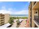 Beach view from a condo balcony with palm trees, lush vegetation, and brick-paved walkways at 8750 Midnight Pass Rd # 501, Sarasota, FL 34242