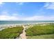 Beautiful beach access with lush greenery and clear blue skies perfect for relaxing and enjoying the ocean breeze at 8750 Midnight Pass Rd # 501, Sarasota, FL 34242