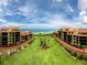 Exterior view of condo buildings surrounding a central lawn and leading to the beach at 8750 Midnight Pass Rd # 501, Sarasota, FL 34242