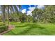 Lush green backyard featuring mature trees and landscaping, offering a serene and private outdoor space at 8832 Enclave Ct, Sarasota, FL 34238