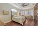 Inviting bedroom with hardwood floors, tray ceiling, and bright sitting area at 8832 Enclave Ct, Sarasota, FL 34238