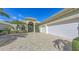 Elegant home featuring a three-car garage and lush landscaping at 8832 Enclave Ct, Sarasota, FL 34238