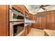 Modern kitchen featuring stainless steel appliances, including a built-in oven and gas range, and custom wood cabinetry at 8832 Enclave Ct, Sarasota, FL 34238