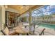 Spacious screened lanai with a stone table, a ceiling fan and a great view of the pool and outdoor space at 8832 Enclave Ct, Sarasota, FL 34238