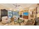 Inviting living room featuring a fireplace, large screen television, plush seating, and access to the outdoor pool area at 8832 Enclave Ct, Sarasota, FL 34238