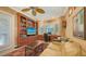 Well-appointed office with custom wood built-ins, comfortable seating, and natural light from the bay window at 8832 Enclave Ct, Sarasota, FL 34238