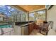Outdoor kitchen boasts a granite countertop, stainless appliances, and a built-in grill overlooking the screened pool at 8832 Enclave Ct, Sarasota, FL 34238