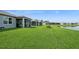 Backyard featuring a spacious green lawn and a serene pond, creating a peaceful outdoor setting at 9566 Coastline Way, Parrish, FL 34219