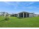 Backyard with a covered lanai and a lush lawn that stretches toward a scenic pond, perfect for outdoor enjoyment at 9566 Coastline Way, Parrish, FL 34219
