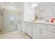 Modern bathroom with a glass-enclosed shower, dual vanities, and tile flooring at 9566 Coastline Way, Parrish, FL 34219