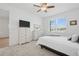 Bright bedroom featuring carpeted floors, window view, and classic dresser furniture with a TV at 9566 Coastline Way, Parrish, FL 34219