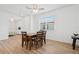 Well-lit dining area with wood floors and a view of the living room and bedroom at 9566 Coastline Way, Parrish, FL 34219
