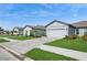 Charming single-story homes with lush lawns and manicured landscaping under a bright blue sky at 9566 Coastline Way, Parrish, FL 34219