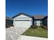 Charming one-story home features a paved driveway, a two-car garage, and beautifully landscaped front yard at 9566 Coastline Way, Parrish, FL 34219