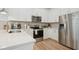 Bright modern kitchen with white cabinets, stainless steel appliances, stone countertops and tiled backsplash at 9566 Coastline Way, Parrish, FL 34219