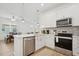 Well-lit kitchen features stainless steel appliances, light wood floors and breakfast bar with a view to the dining and living area at 9566 Coastline Way, Parrish, FL 34219